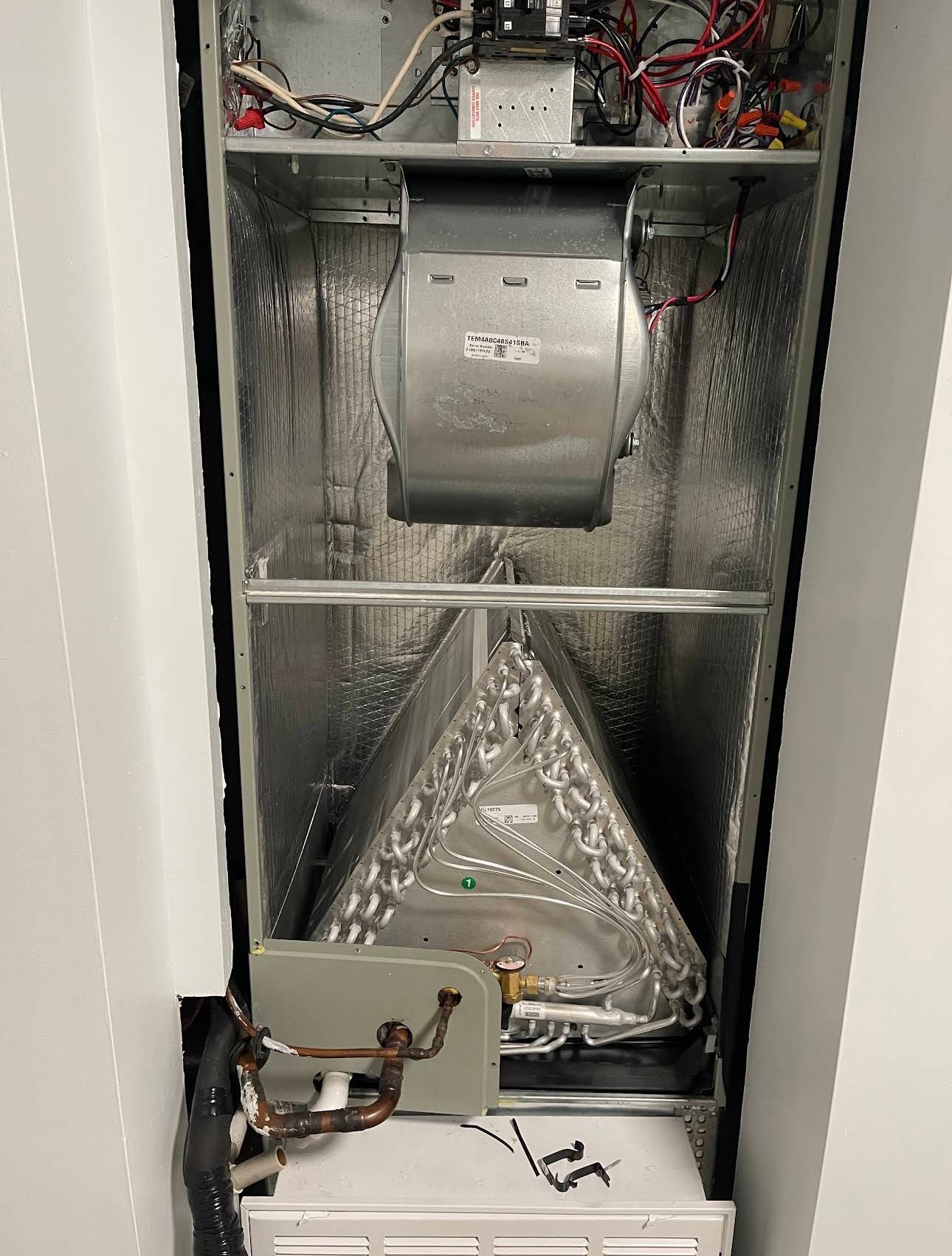 Technician removing an access panel to service an indoor air handler